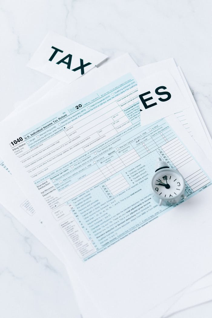 A US tax form 1040 with a small clock on a marble surface symbolizing tax deadline urgency.